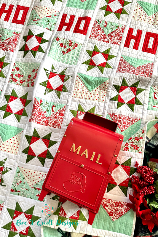 Festive quilt with red and green star patterns, alongside a red metal mail mailbox for holiday decor.