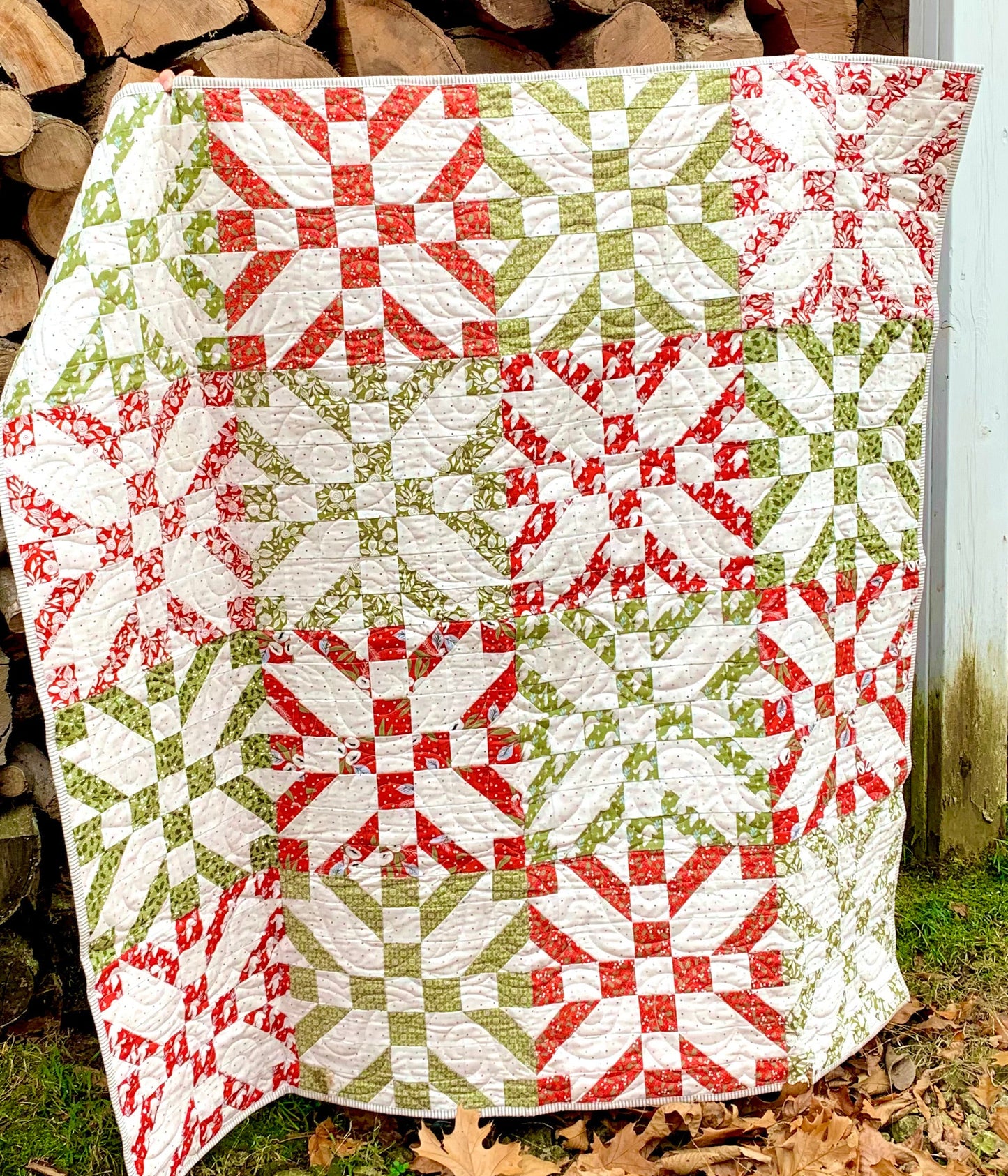 Colorful quilt featuring red, green, and white patterns, crafted from high-quality fabric, perfect for cozy decor.
