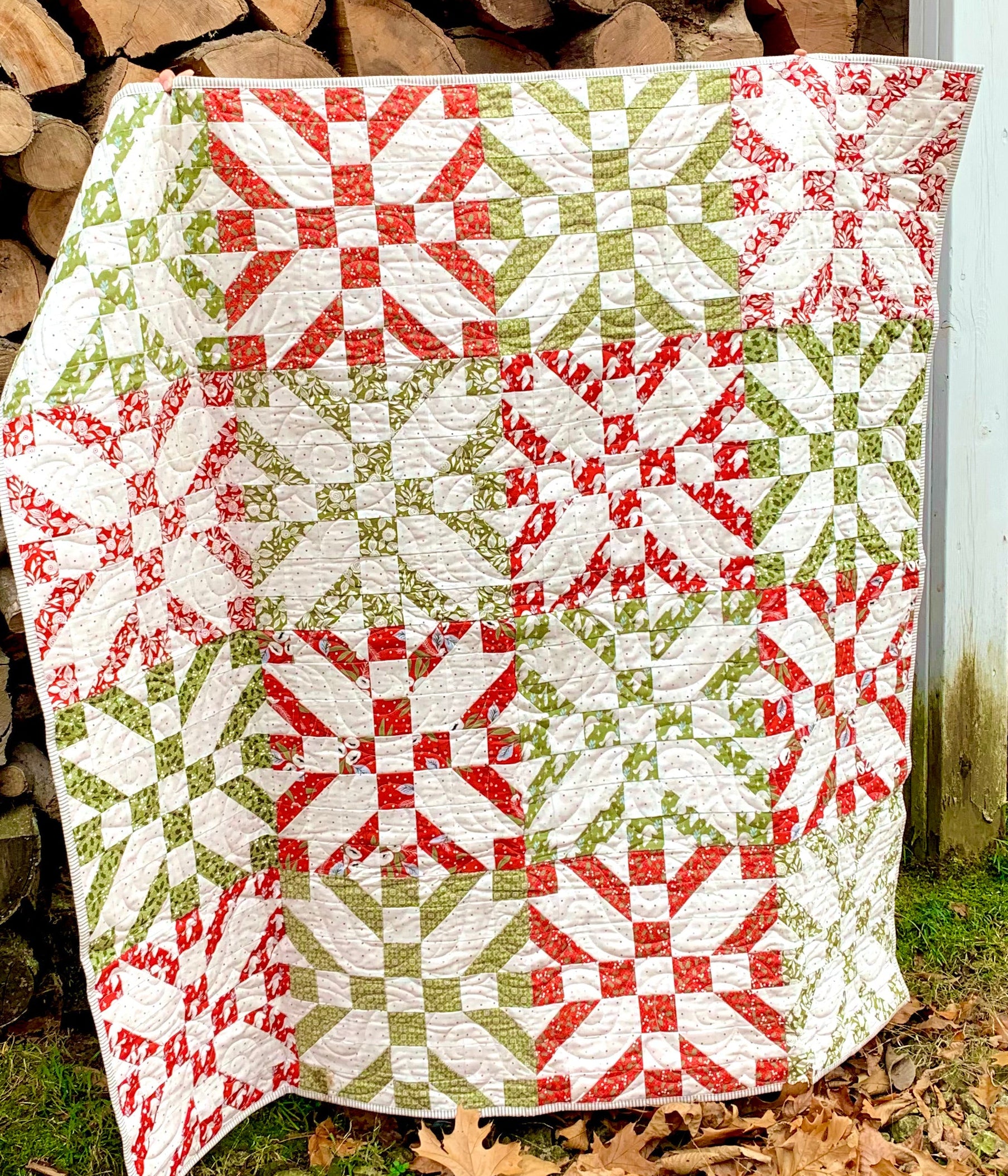 Colorful quilt featuring red, green, and white patterns, crafted from high-quality fabric, perfect for cozy decor.