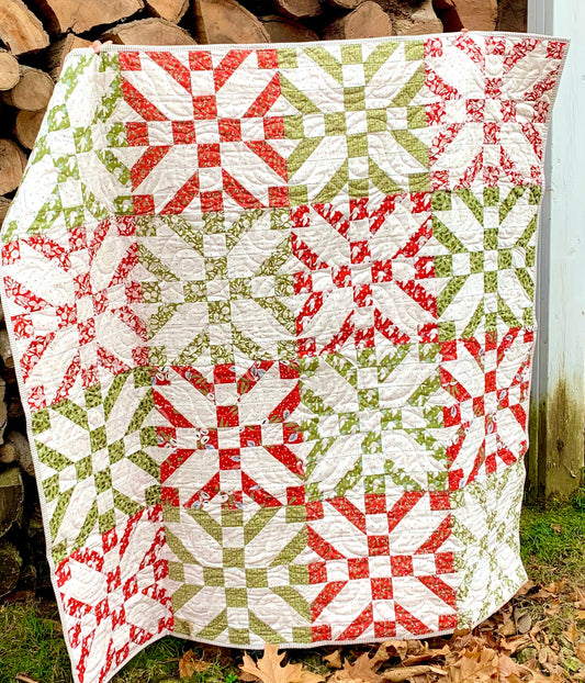 Colorful quilt featuring red, green, and white patterns, crafted from high-quality fabric, perfect for cozy decor.