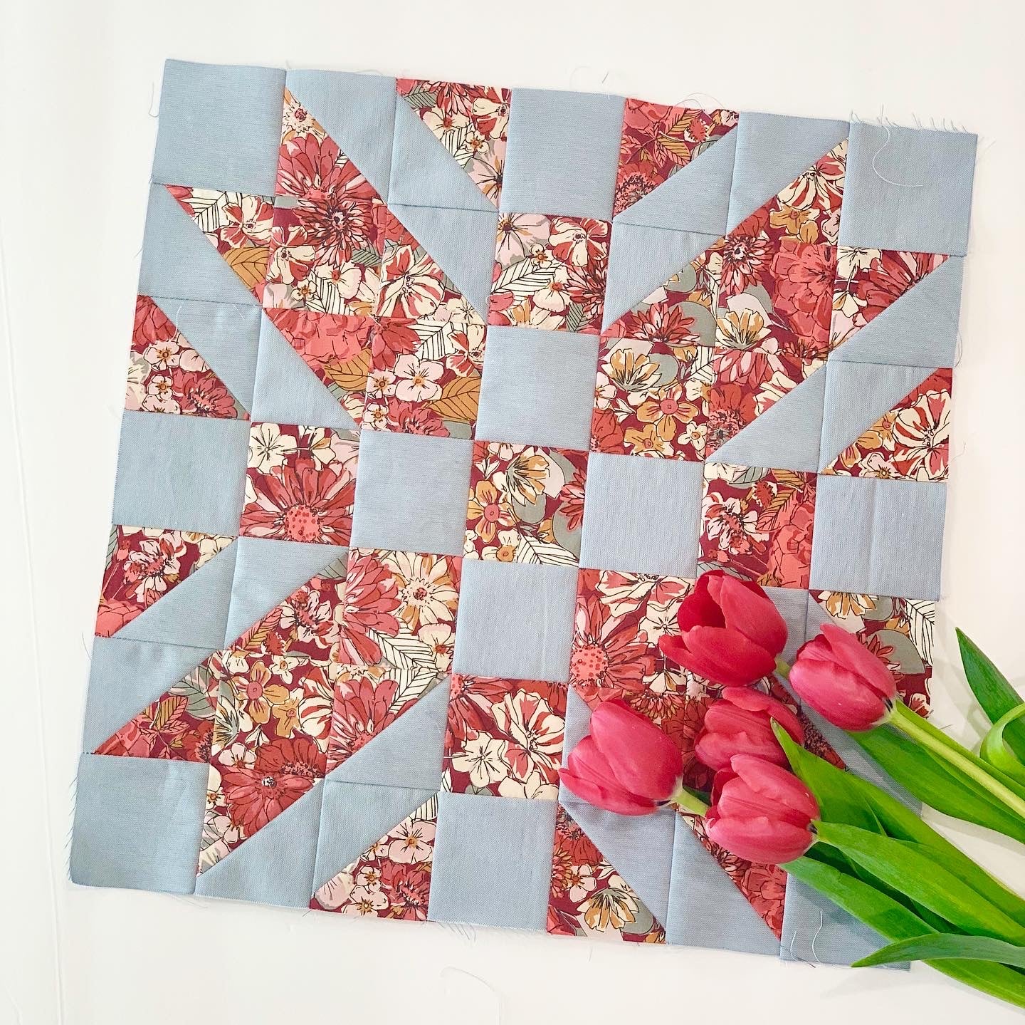 Patchwork quilt square with floral and blue fabric patterns, perfect for home decor projects.