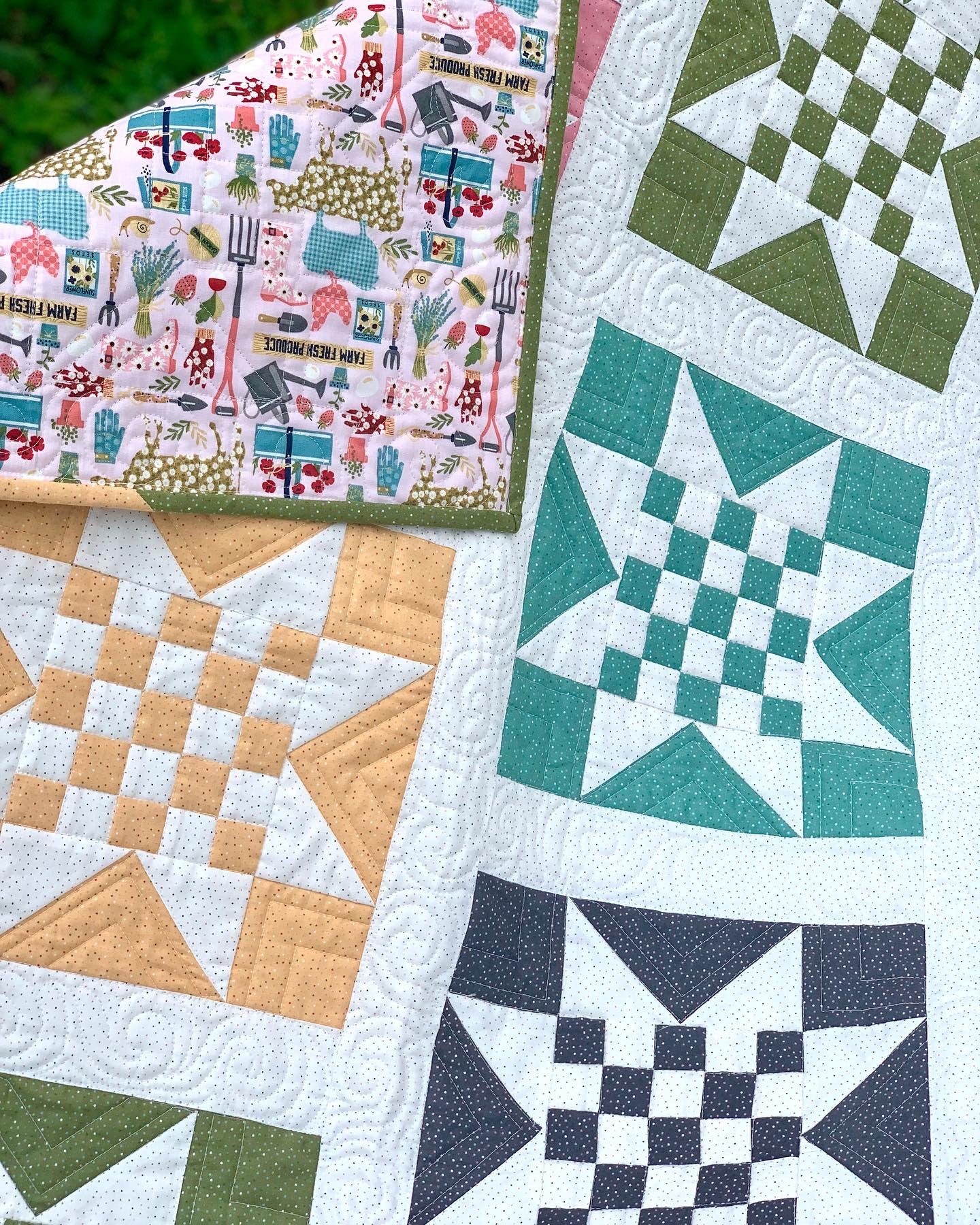 Colorful quilt featuring star patterns in green, teal, and orange with floral backing, handmade from cotton.