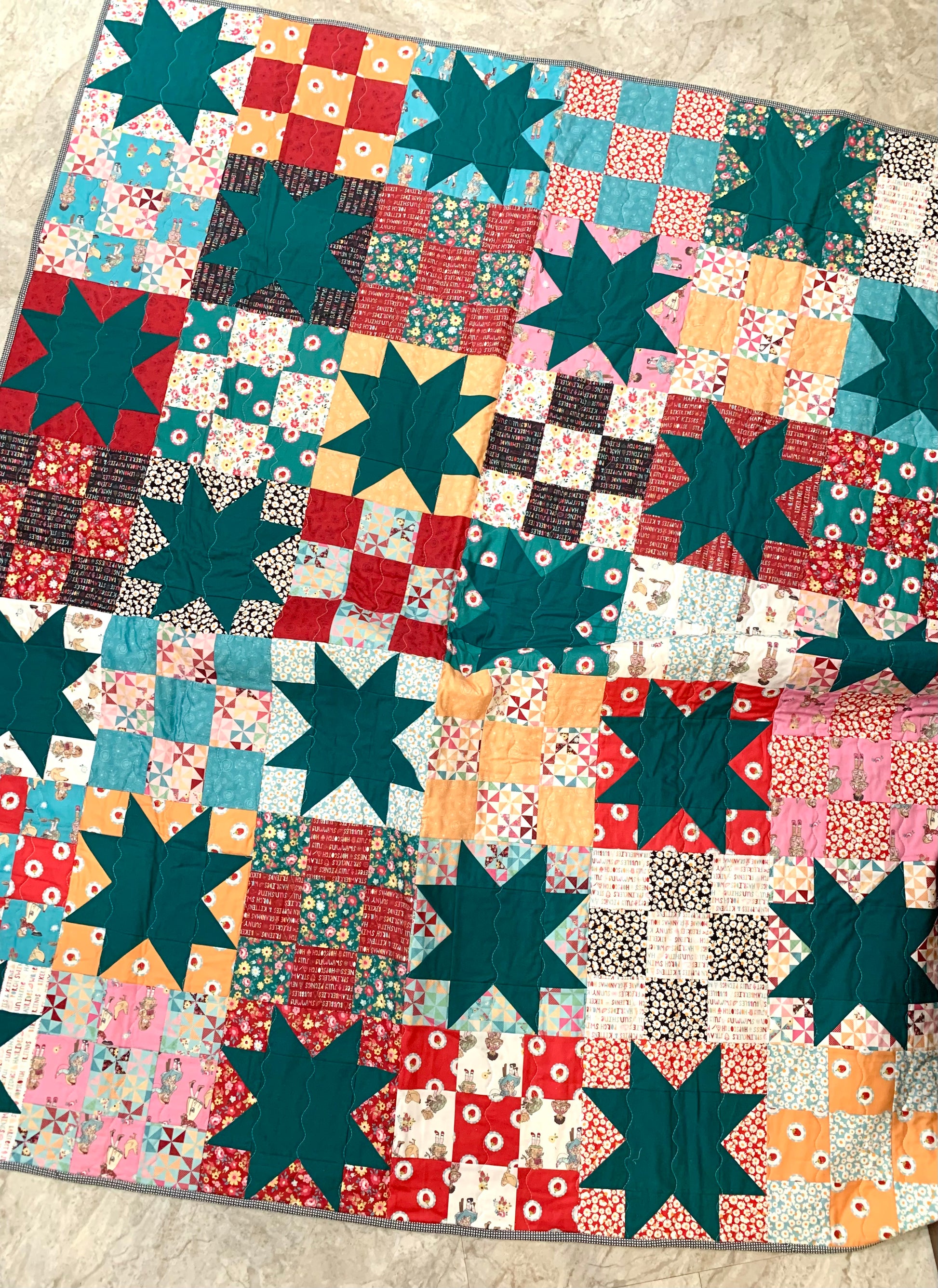 Colorful patchwork quilt featuring teal stars, floral patterns, and vibrant squares, perfect for cozy decor.