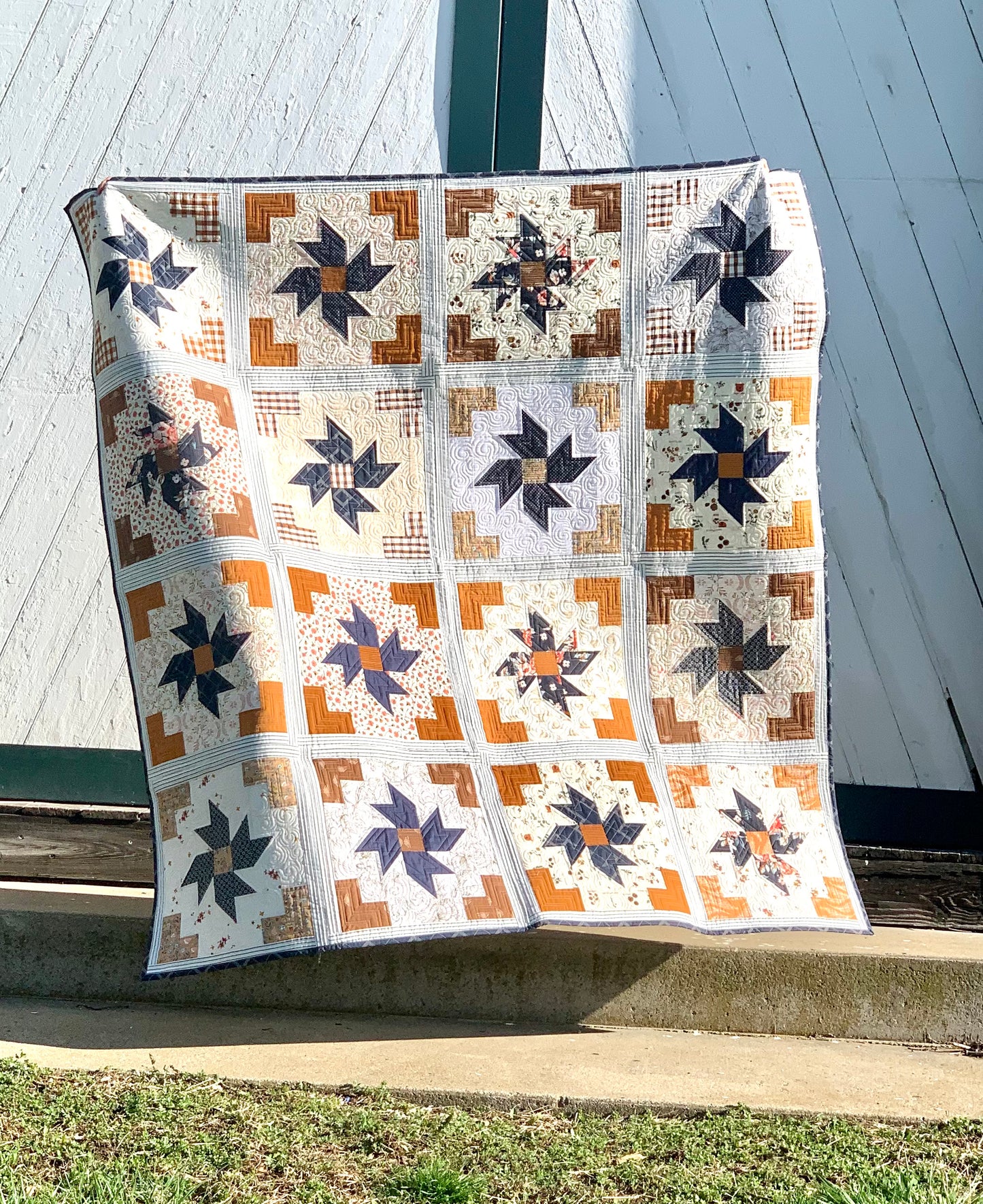 Handcrafted quilt in warm tones, featuring intricate star patterns in blues and browns, made from high-quality fabric.