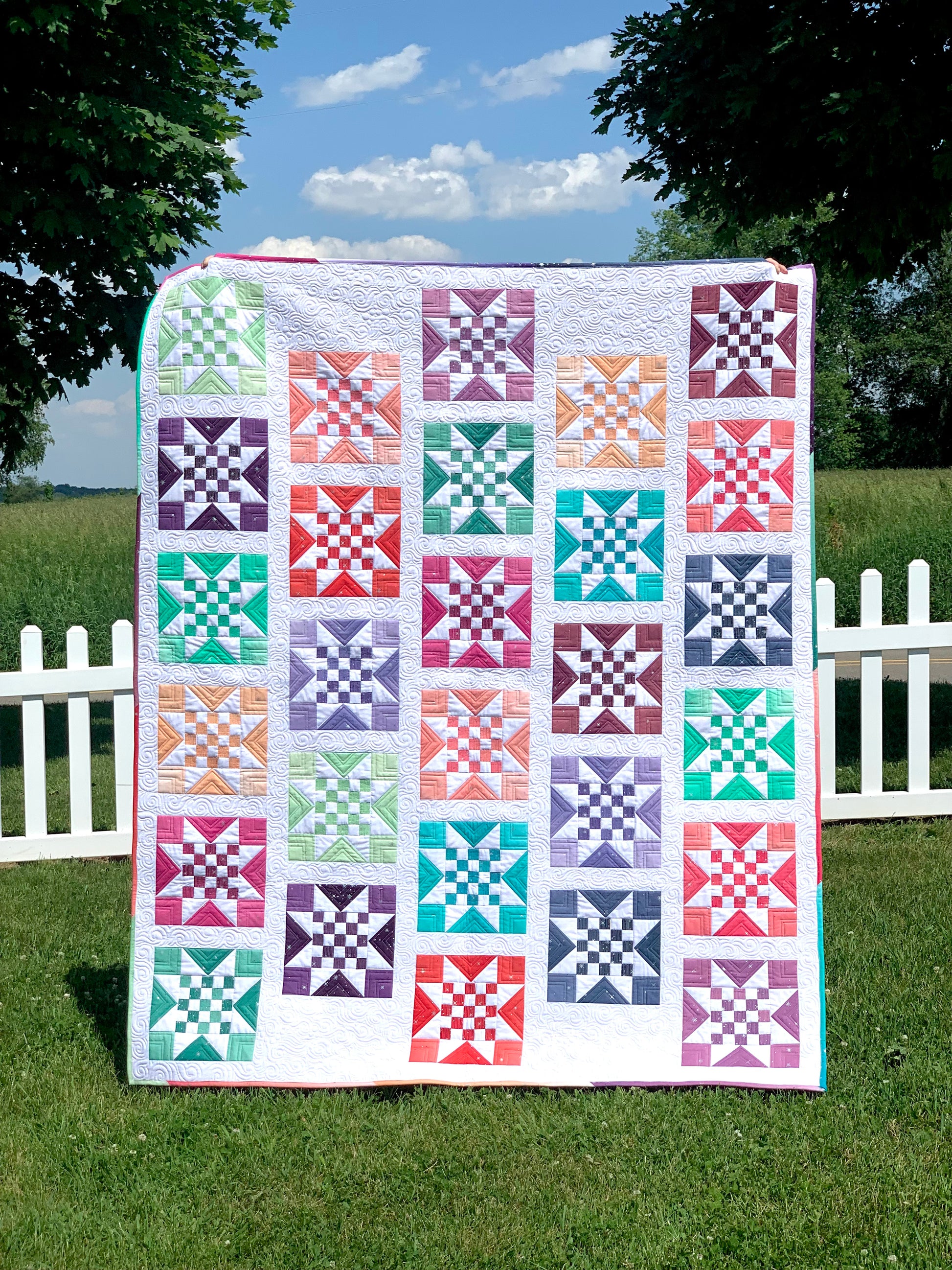 Colorful patchwork quilt featuring star patterns in various shades, made from premium cotton.