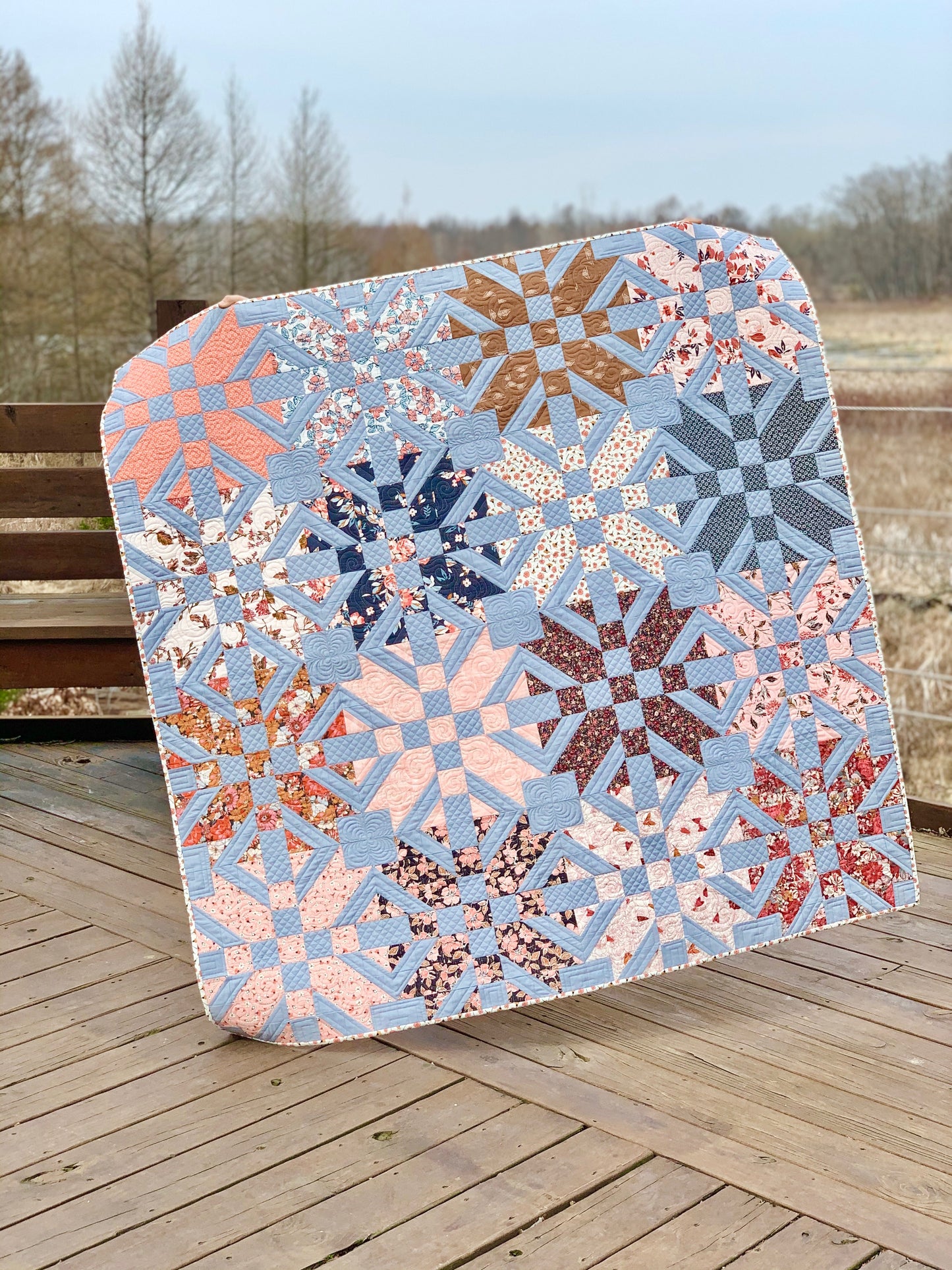 Beautiful blue and pink quilt featuring intricate patterns and floral designs, perfect for home decor.