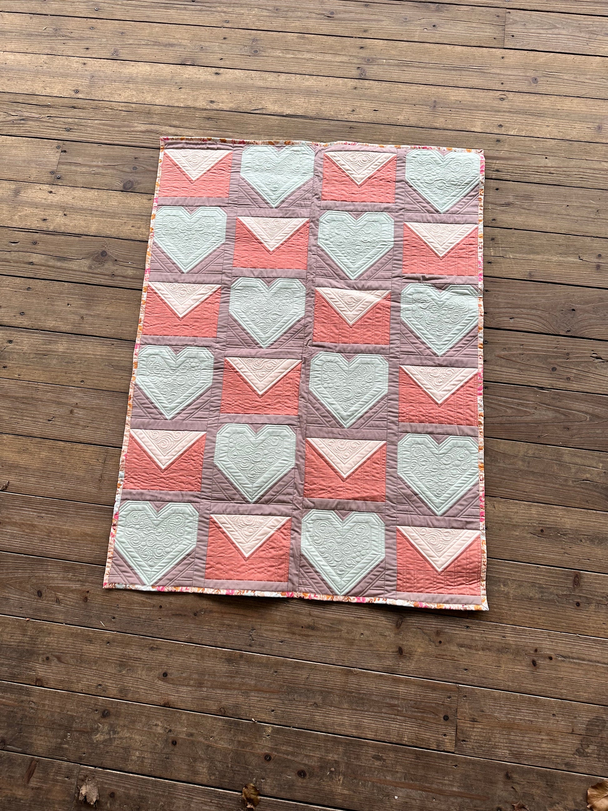 Colorful quilt featuring hearts and envelopes, made of soft cotton fabric, perfect for cozy home décor.