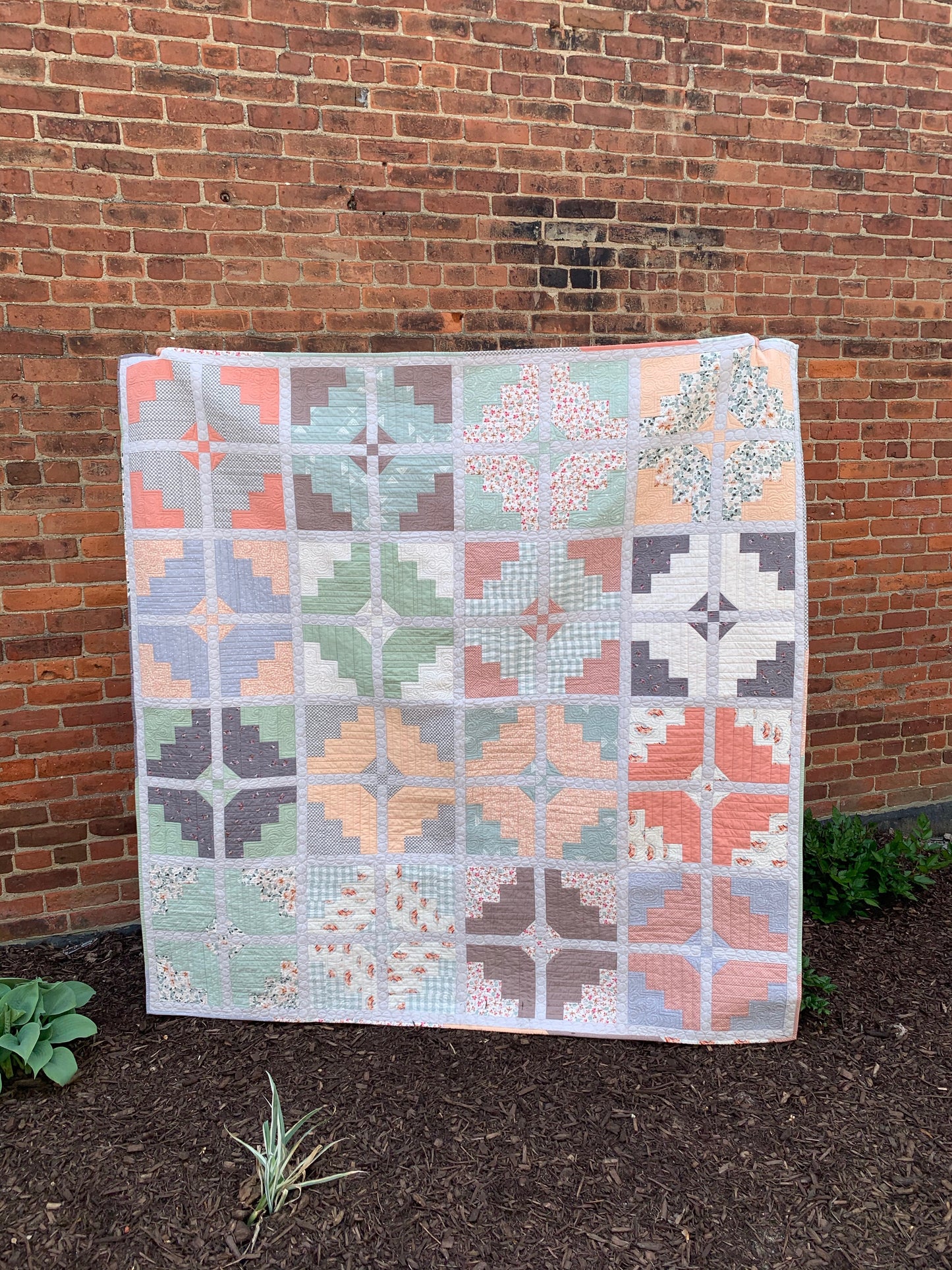 Colorful quilt in pastels and neutrals, featuring intricate patchwork patterns and premium cotton fabric.