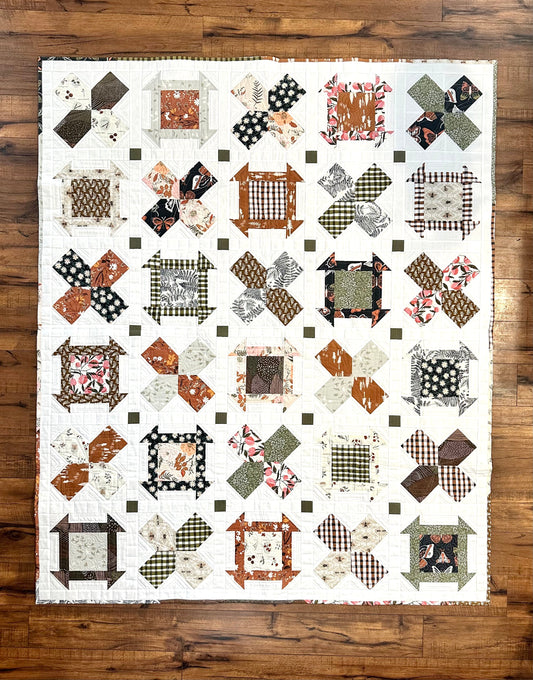 Colorful patchwork quilt featuring floral and geometric designs in earthy tones, perfect for home decor.