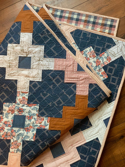 Cozy quilt in navy, floral, and tan patterns, made of cotton, perfect for home decor.