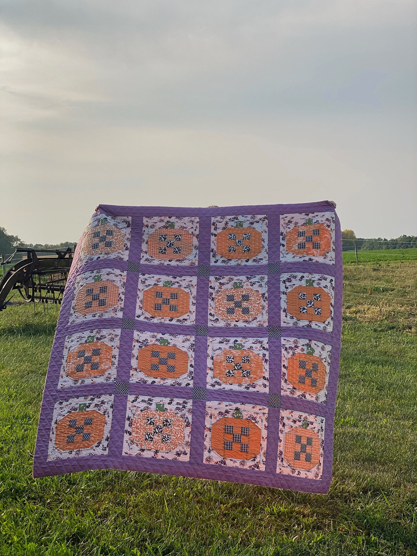 Colorful pumpkin patch quilt in purple, featuring floral patterns and autumn themes, perfect for cozy decor.