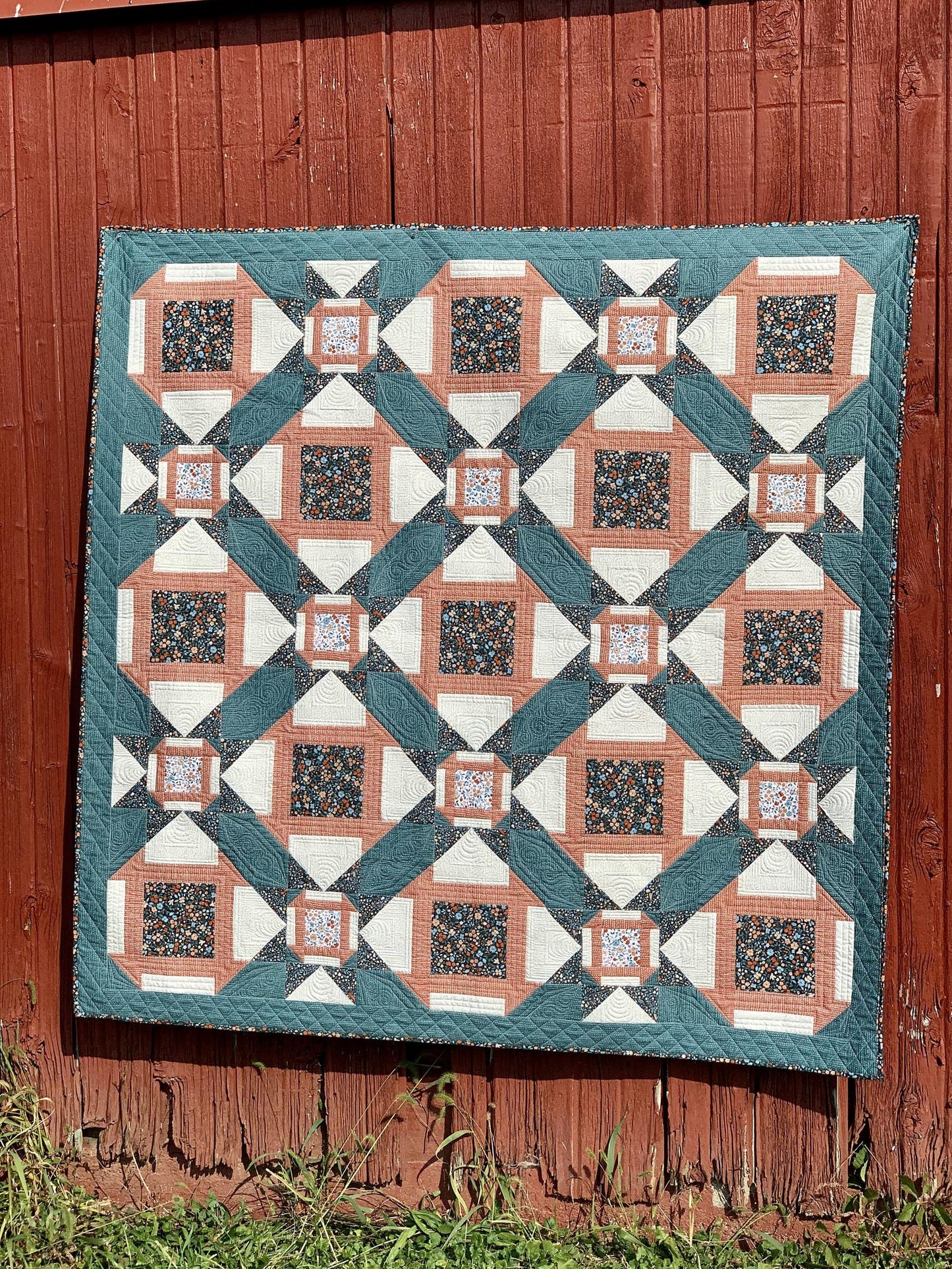 Colorful quilt featuring floral and geometric patterns in teal, coral, and white, perfect for home decor.