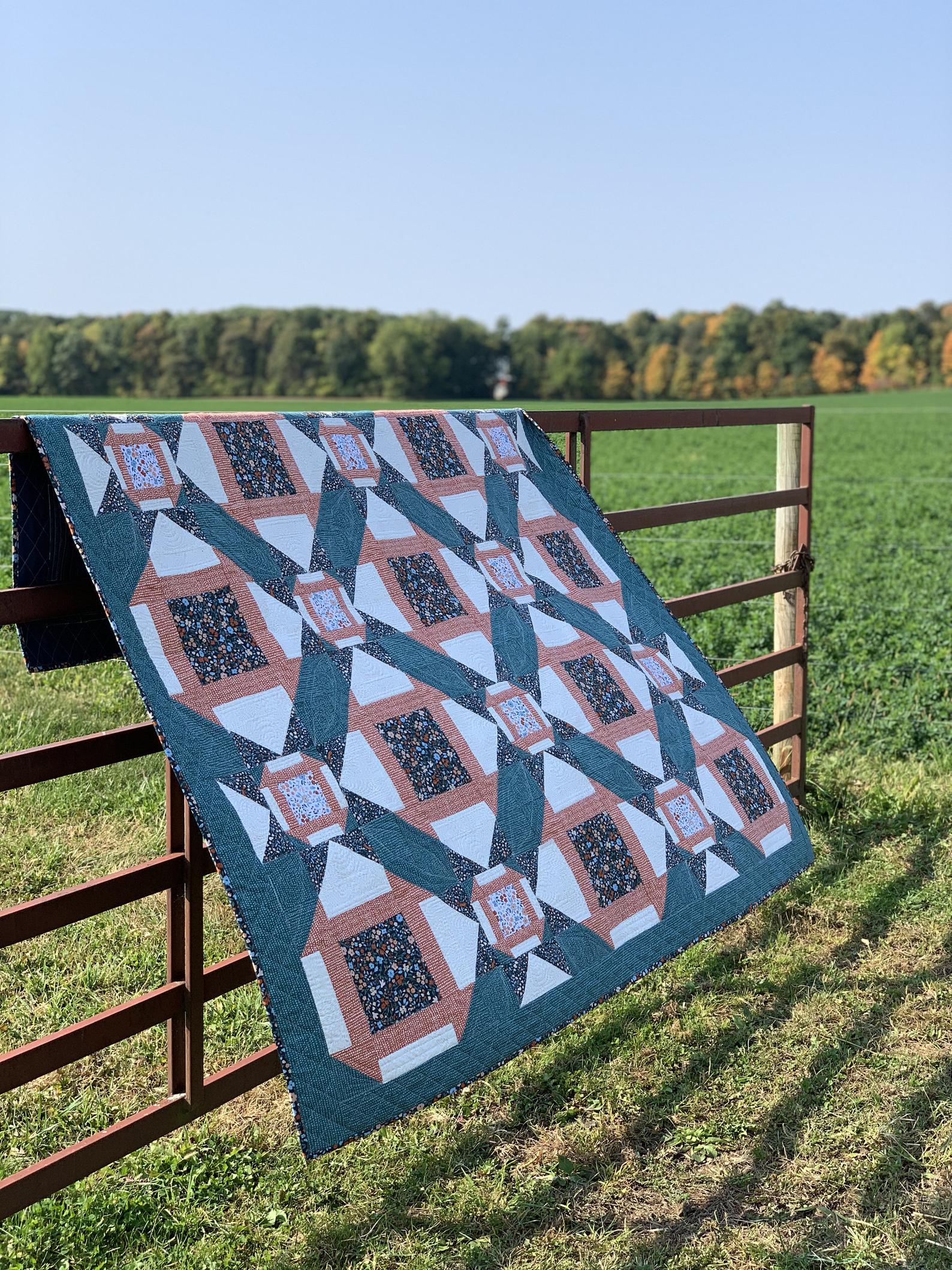Handmade quilt in teal, orange, and white patterns, ideal for home decor or cozy evenings.