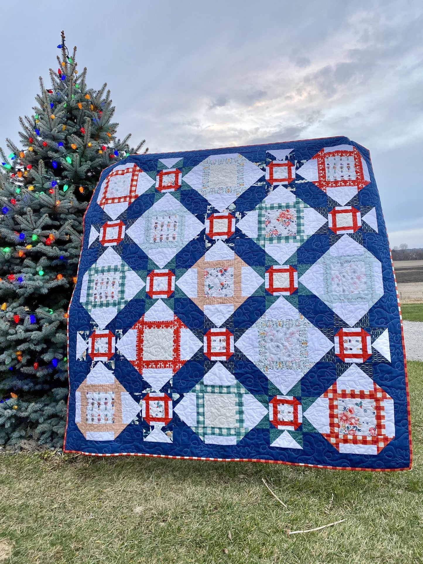 Handmade quilt with navy blue, red, and white patterns, perfect for cozying up during the holidays.